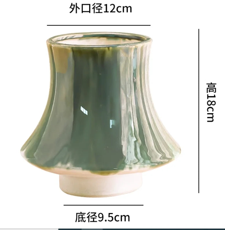 Vase en céramique vert olive de forme élégante avec une ouverture de 12 cm de diamètre et une hauteur de 18 cm.