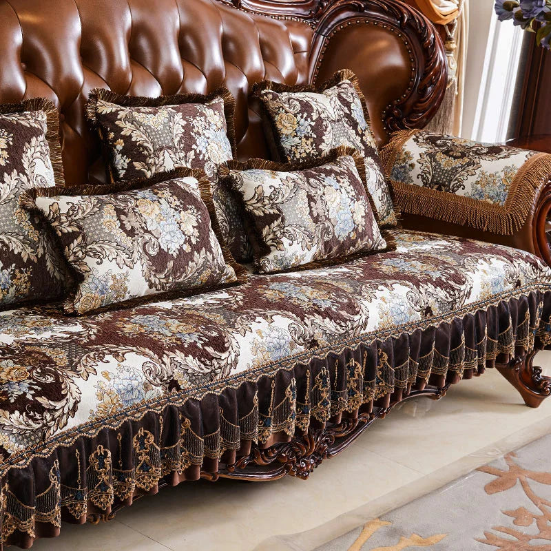 Canapé de luxe avec des coussins décorés de motifs floraux élégants et une finition en cuir brun foncé, créant une atmosphère d'élégance et de confort.