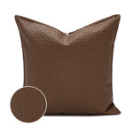 Coussin décoratif marron avec motif géométrique élégant.