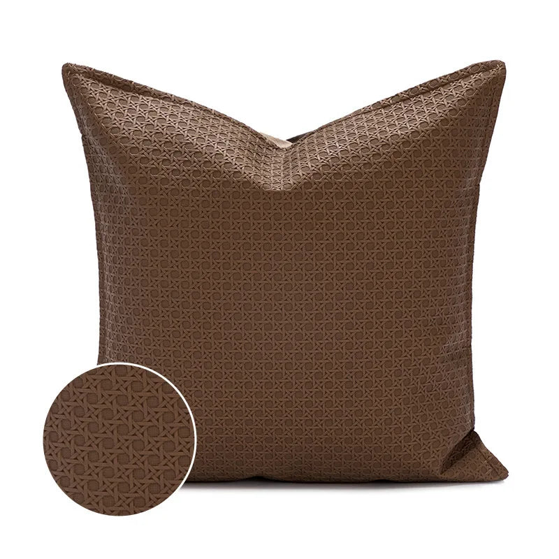 Coussin décoratif marron avec motif géométrique élégant.