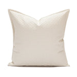 Oreiller décoratif blanc en coton, doté d'un motif discret et élégant.