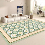 Tapis décoratif fleuri aux motifs verts et blancs ornés, posé sur un sol clair dans un salon moderne avec canapé blanc.