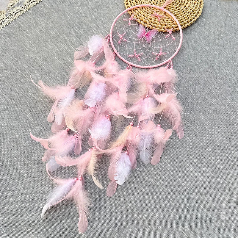 Un capteur de rêves rose décoré de plumes légères et d'une toile d'araignée ajoute une touche de douceur et de féminité à cette scène apaisante.