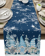 Une table de Noël décorée avec une nappe imprimée de motifs de flocons de neige, de sapins et de gnomes mignons dans un paysage enneigé.