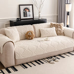 Un canapé moelleux avec des motifs géométriques, accompagné d'un cadre décoratif et d'un vase de fleurs, créant une ambiance chaleureuse et invitante dans cette pièce de style moderne.