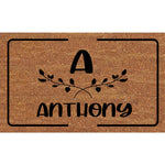 tapis d'entrée marron clair lettre feuilles stylisées texte ANTHONY moderne minimaliste