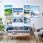 Cette image présente une série d'affiches de destination de montagne et de paysages d'hiver, créant une ambiance chaleureuse et inspirante dans un salon moderne et minimaliste.