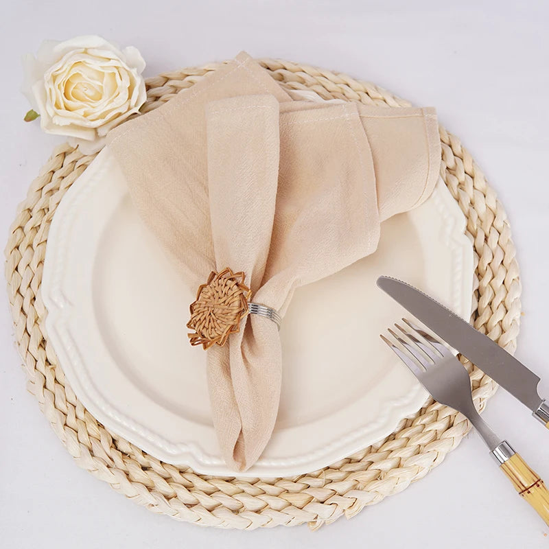 Un beau cadre élégant avec assiette, couverts et une fleur blanche sur un napperon en paille.
