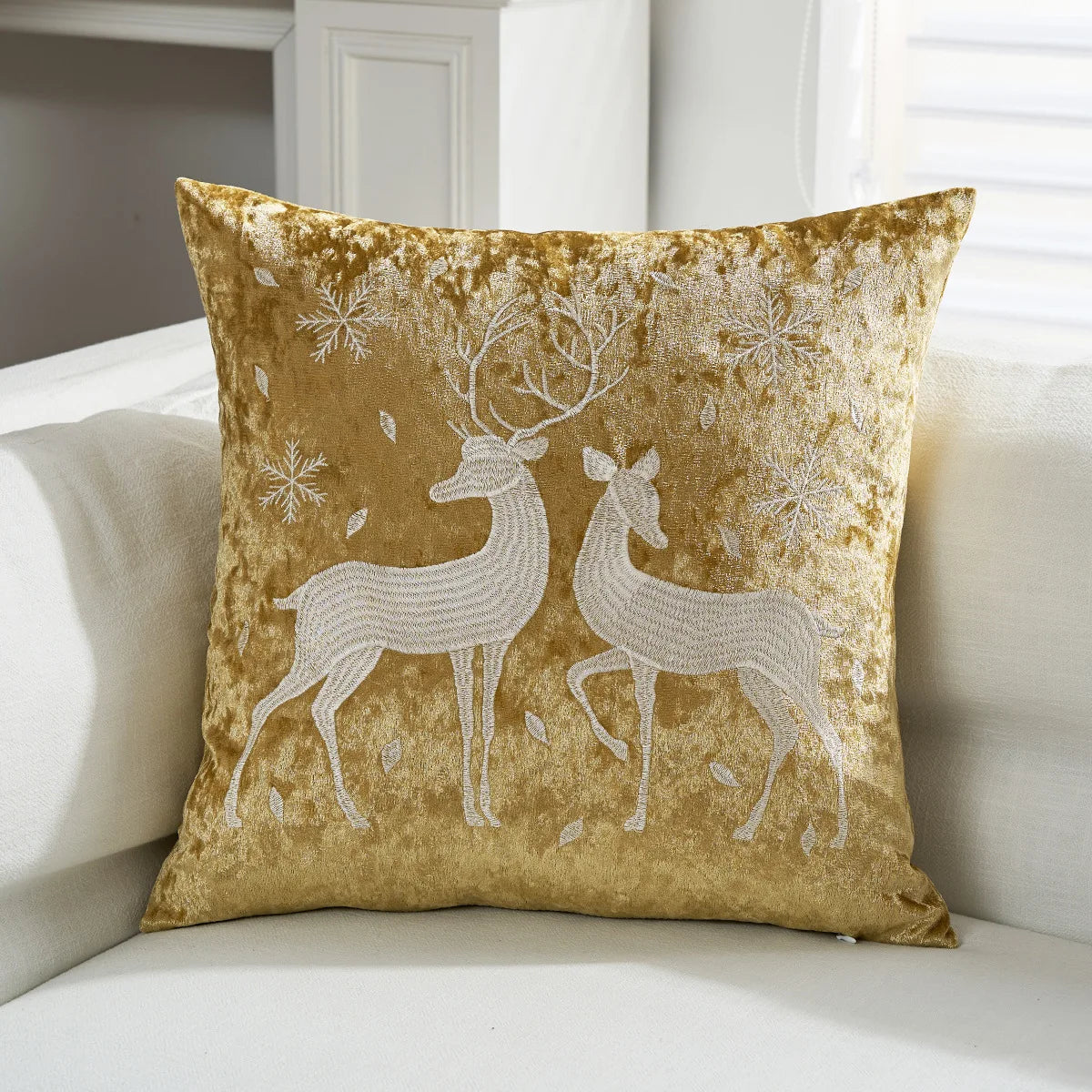 Coussin décoratif aux motifs de cerfs argentés sur un fond doré, créant une ambiance festive et élégante.