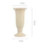 Vase en céramique de couleur beige clair de forme élancée avec une bordure ondulée pour une décoration élégante et raffinée.