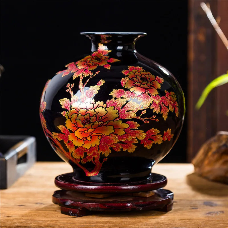 Un magnifique vase en céramique noire orné de fleurs d'automne dorées et rouges, créant une superbe pièce décorative.