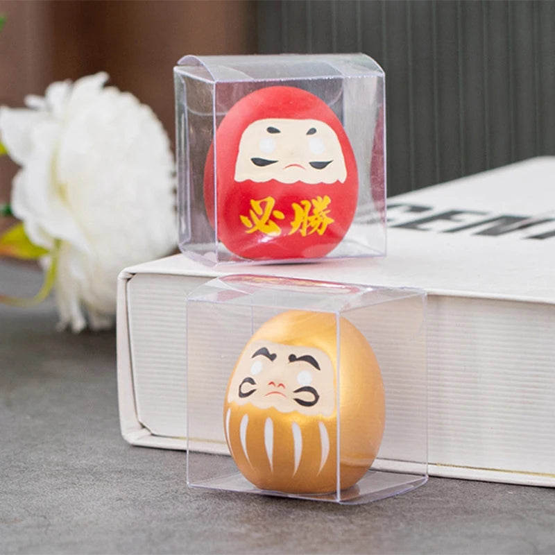statuette japonaise daruma rouge or visage stylisé sourcils yeux barbe blanche traditionnelle décoration maisonporte