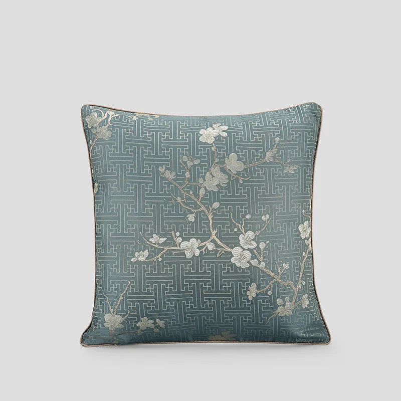 Coussin ornemental de couleur verte olive avec des motifs floraux et géométriques enchevêtrés.