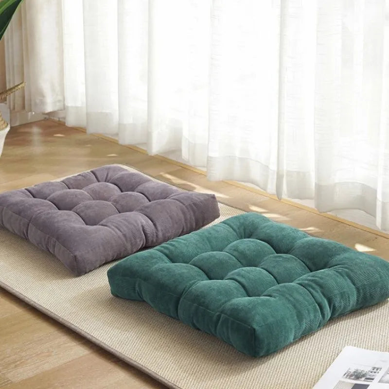Coussin de sol carré en velours côtelé rouge sur un parquet en bois