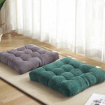 Coussin de sol carré en velours côtelé rouge sur un parquet en bois