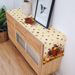 Un meuble de rangement en bois avec des feuilles d'automne colorées et une image de dinde, créant une ambiance chaleureuse et automnale.