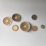 Une collection de paniers décoratifs tissés aux motifs géométriques naturels et harmonieux, créant une ambiance chaleureuse et authentique.