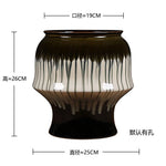 Vase décoratif à motif sculpté en céramique noire avec des lignes blanches sur sa partie supérieure, doté d'un design unique et élégant.