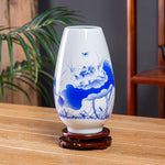 Vase en porcelaine blanche décoré de fleurs de lotus bleu sur un support en bois.