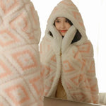 Une femme enveloppée dans une chaude couverture douce et moelleuse, avec un capuchon pour se protéger du froid.