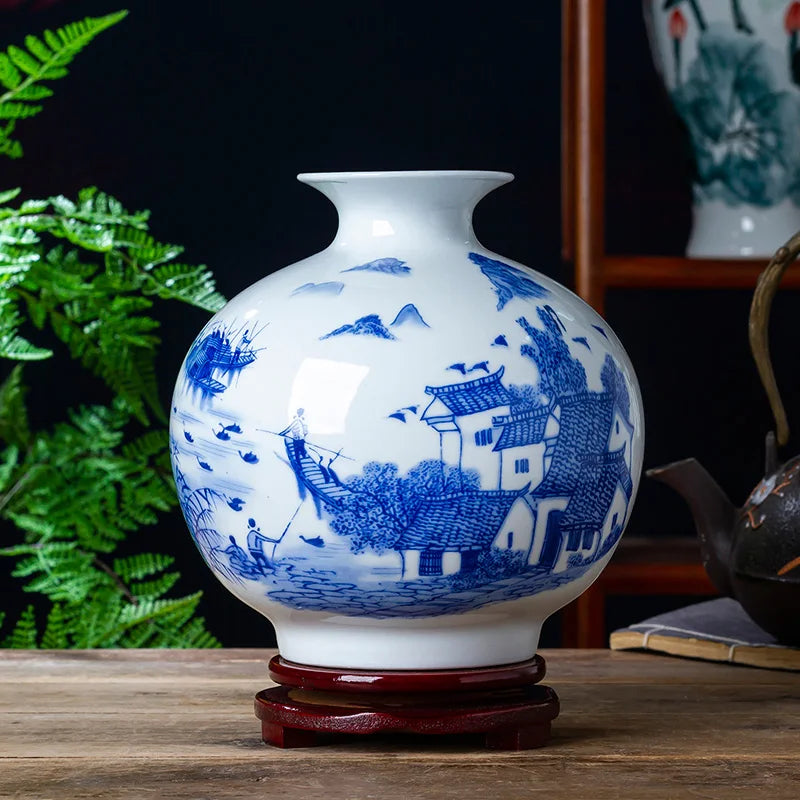 Vase en porcelaine blanche avec des motifs bleus représentant un paysage chinois traditionnel.