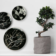 assiettes murales céramique noires blanches motifs floraux branches stylisées décoration intérieure asiatique minimaliste élégante