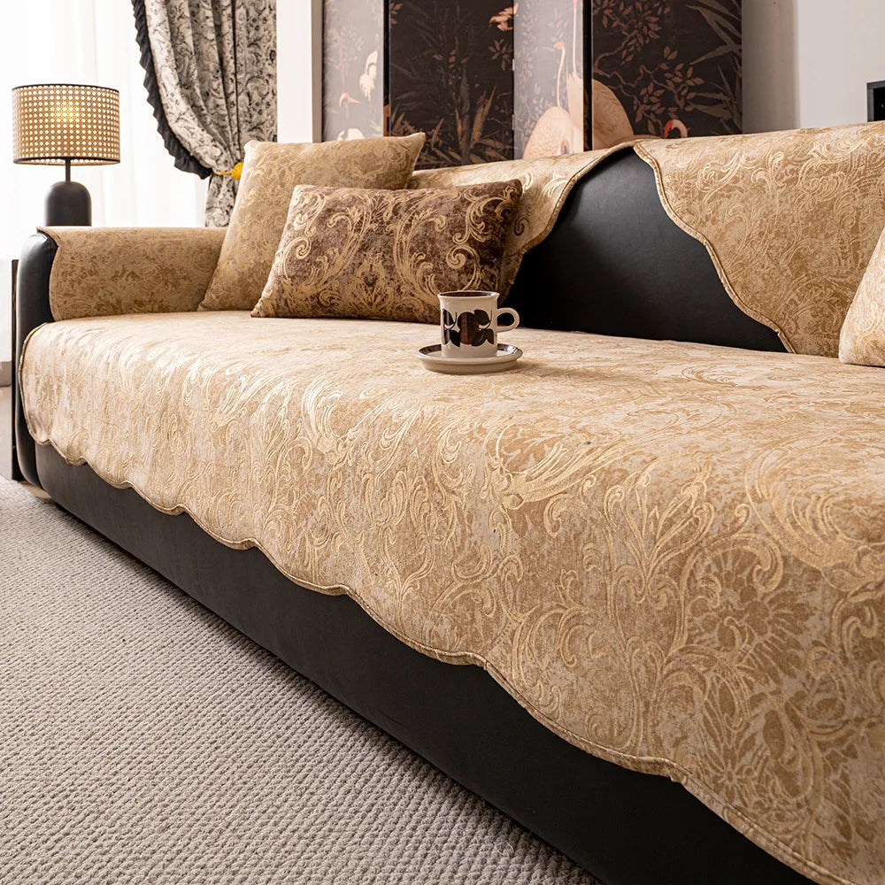 Un canapé confortable et élégant aux motifs dorés, orné de coussins assortis, posé sur un tapis moelleux, dans un intérieur chaleureux et accueillant.