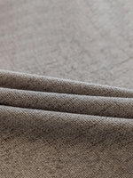 Détail du tissu texturé du voilage occultant gris clair posé à plat.