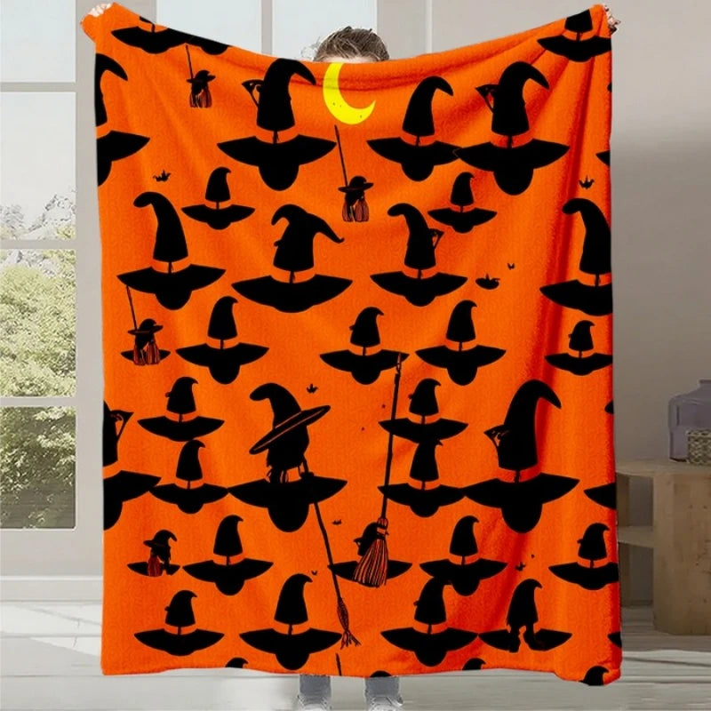 Couverture orange avec des motifs de sorcières noires pour célébrer Halloween.