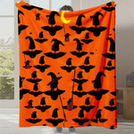 Couverture orange avec des motifs de sorcières noires pour célébrer Halloween.