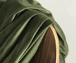 Tissu de rideau occultant kaki vert olive en velours posé sur un fauteuil