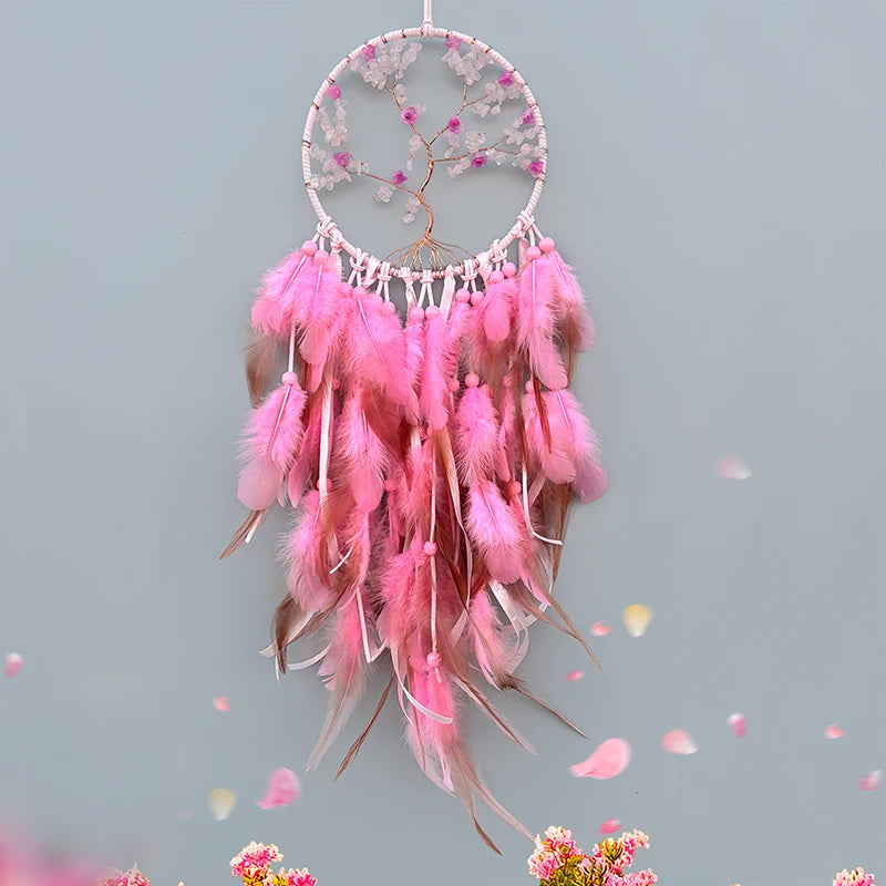 Un attrape-rêves décoratif rose suspendu, orné de plumes et de cristaux scintillants, créant une atmosphère whimsique et féerique.