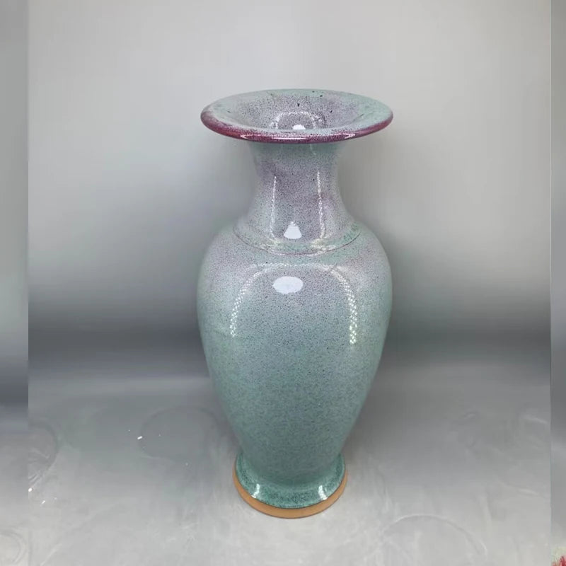 Vase en céramique de couleur gris-vert avec des touches de rose, doté d'un design irrégulier créant un effet de texture.