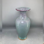 Vase en céramique de couleur gris-vert avec des touches de rose, doté d'un design irrégulier créant un effet de texture.