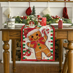Un décor de table festif avec un chemin de table illustré d'un bonhomme en pain d'épices dans un style de Noël traditionnel.