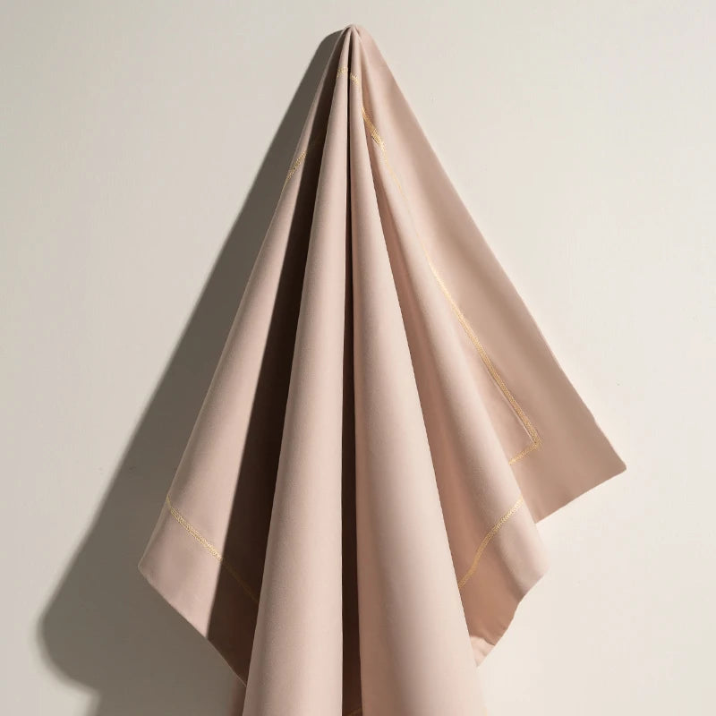 Une mince étoffe de couleur rose pastel aux plis élégants, évoquant une élégance et une sophistication raffinées.