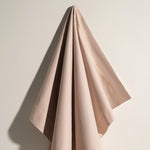 Une mince étoffe de couleur rose pastel aux plis élégants, évoquant une élégance et une sophistication raffinées.