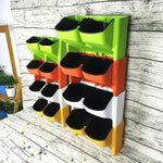 Système jardinage vertical moderne pots différentes tailles plantes fleurs mur orange vert jaune