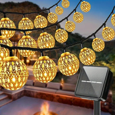 Guirlande lumineuse solaire boule marocaine allumée dans un jardin