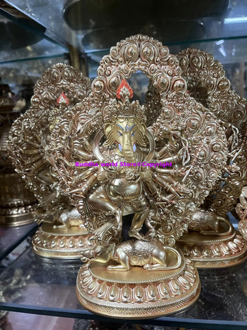 statuette dorée ganesha divinité éléphant détails sculpturaux motifs floraux socle orné structure arquée complexe