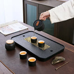 plateau thé noir insert doré traditionnel asiatique service table texture bois clair tasses théière