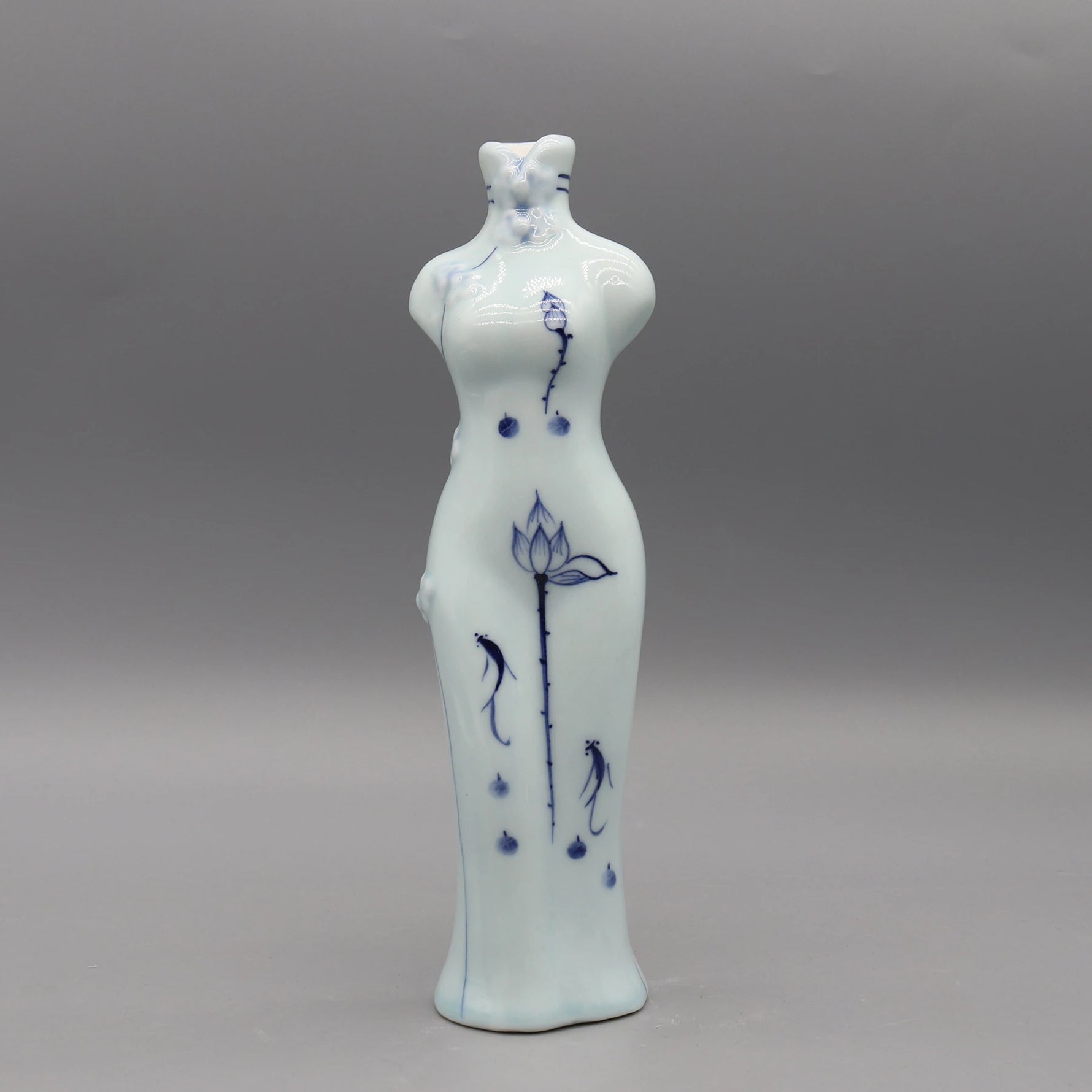 Représentation en porcelaine d'une forme féminine aux contours gracieux, décorée de motifs floraux et aquatiques dans des tons bleus, évoquant une vision apaisante et poétique.