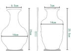 Il s'agit d'un vase en forme cylindrique, avec un rétrécissement au milieu et une base plus large. Les dimensions indiquées sont 14 cm de hauteur, 6,5 cm de largeur maximale et 7 cm de largeur à la base.