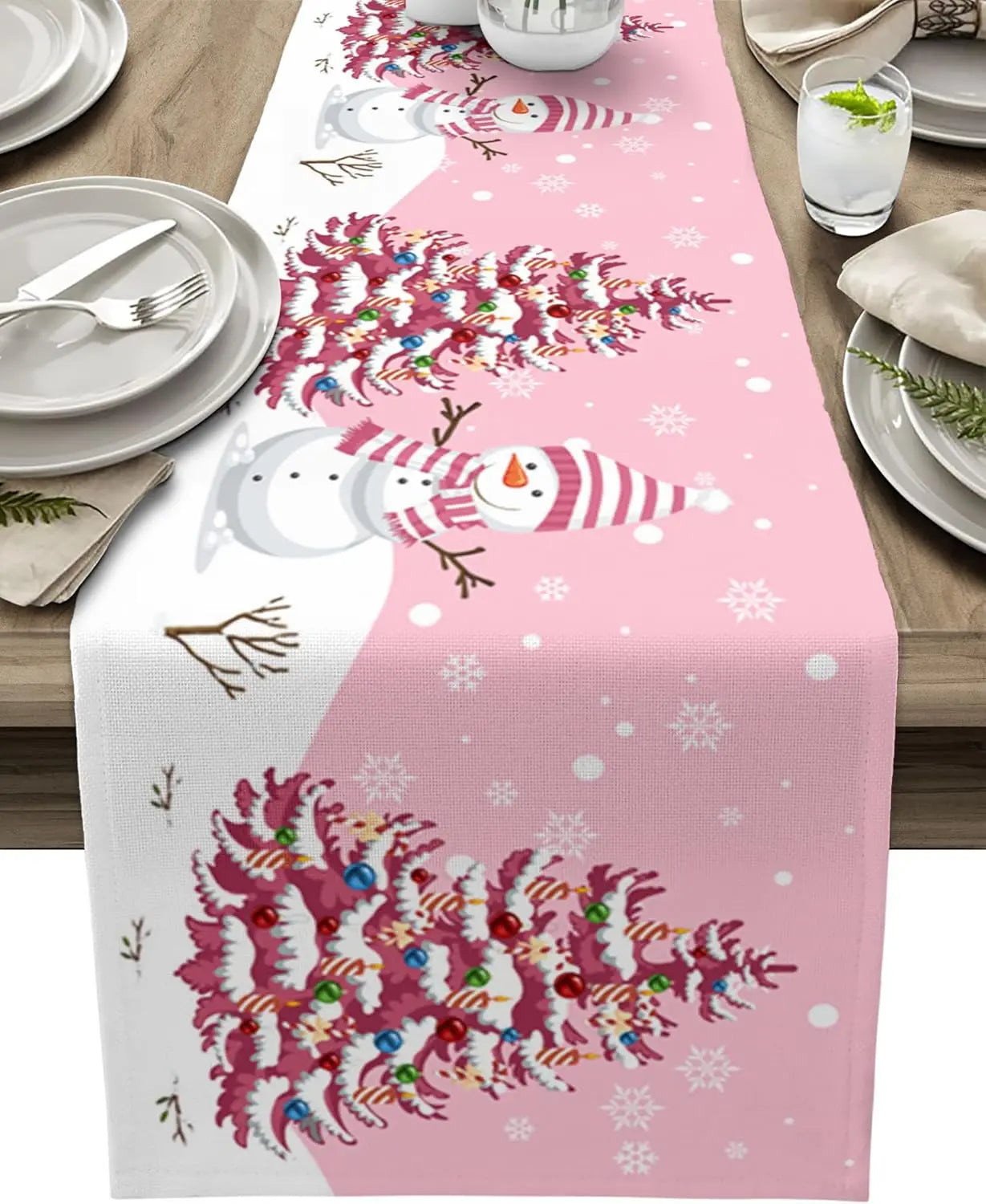 Le chemin de table rose avec des flocons de neige et des motifs de bonhommes de neige festifs crée une ambiance hivernale chaleureuse pour cette table de fête.
