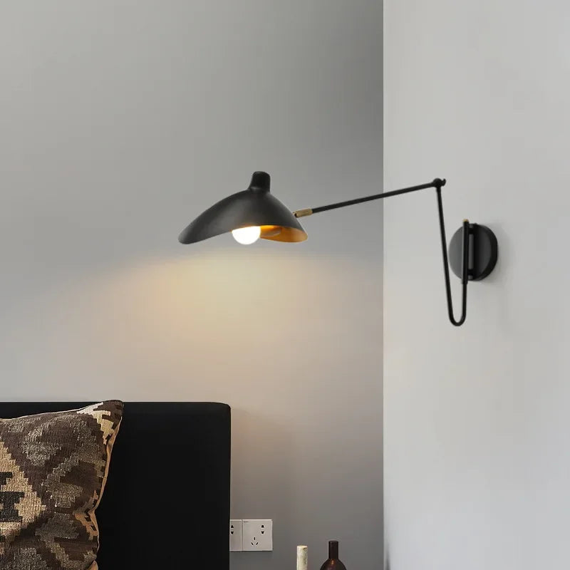 Lampe de lecture design blanche installée au-dessus d'un lit contemporain