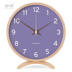 horloge moderne bois naturel cadran blanc chiffres noirs fond violet gris