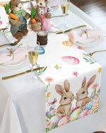 La table est décorée avec des figurines de lapins mignons et des motifs floraux printaniers, accompagnés de flûtes de champagne, dans une ambiance festive et élégante.