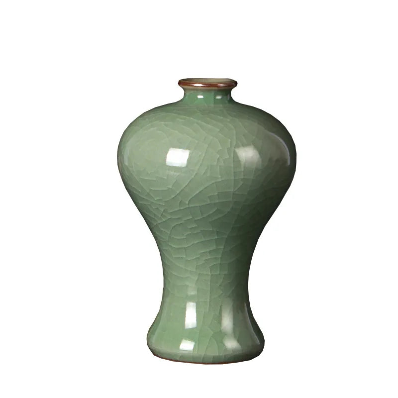 Vase en céramique vert foncé orné de motifs gravés, avec un col arrondi et une forme élancée.