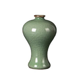 Vase en céramique vert foncé orné de motifs gravés, avec un col arrondi et une forme élancée.