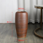 Un vase décoratif en céramique brun aux motifs ondulés, mesurant 41 cm de hauteur et 15 cm de diamètre.